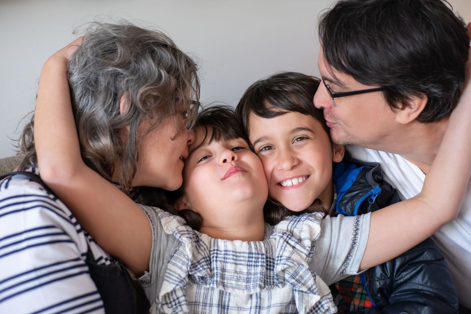 Parents hugging their two children, the kind of family autism friendly cruise lines serve