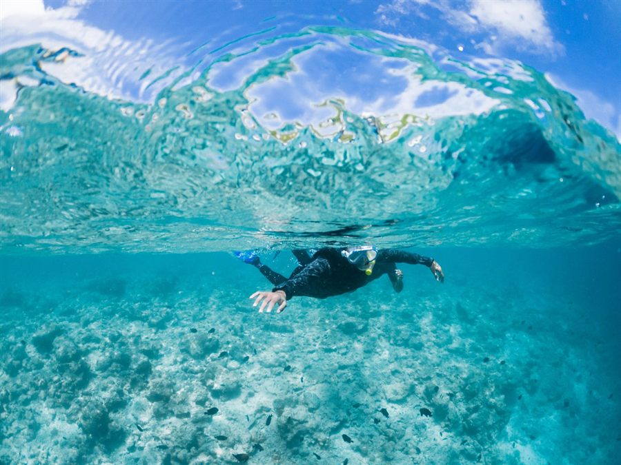 Swimmer gliding through clear turquoise water