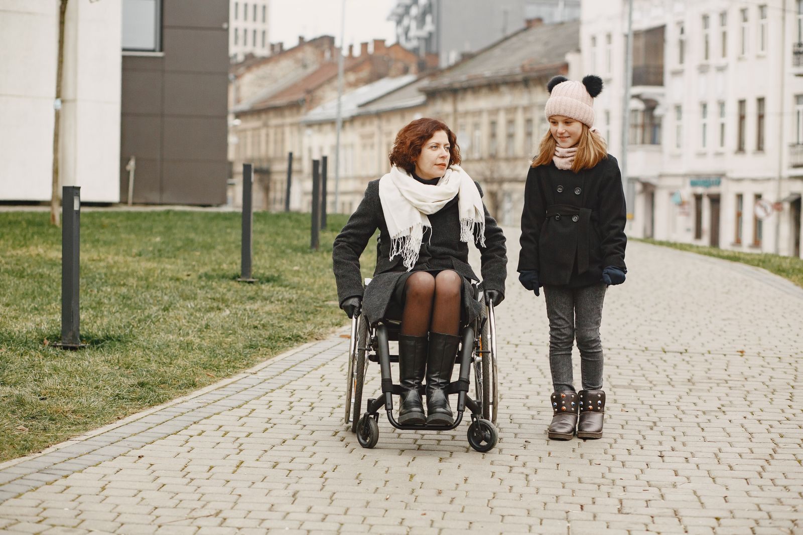 Two friends walking together, one using a wheelchair, planning special needs cruises